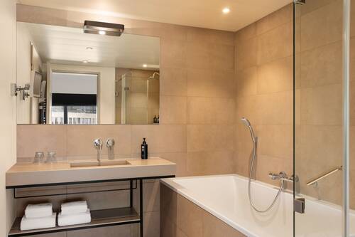 Hochwertiges Badezimmer mit Dusche und Badewanne im Studio Deluxe.