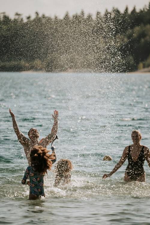 A family is cooling off in a swimming lake.
