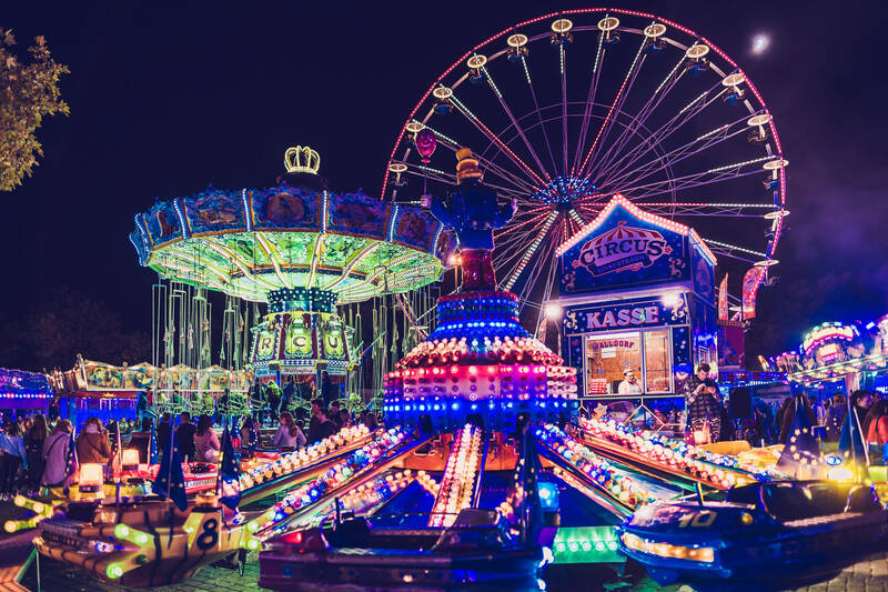 Der Gallusmarkt in Wetzlar mit Riesenrad und Fahrgeschäften ist bunt erleuchtet.