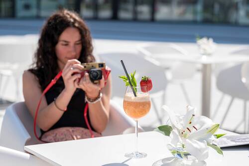 Eine junge Frau fotografiert ihren Cocktail im Café Leitz.