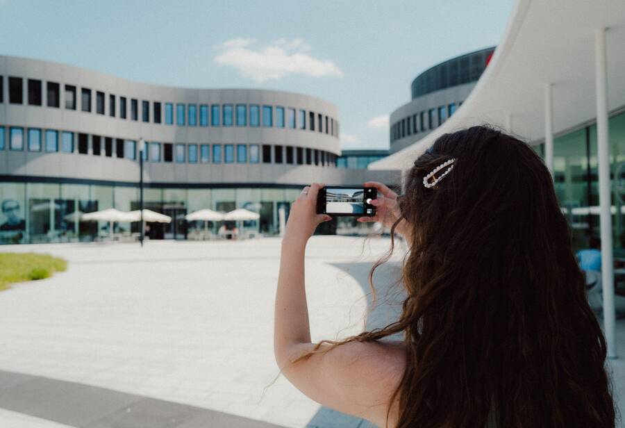 Eine Frau fotografiert mit ihrem Smartphone ein Gebäude im Leitz-Park Wetzlar.