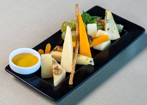 Tasty mixed cheese with sauce on the black plate