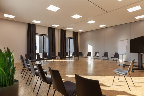 Großer Stuhlkreis im hellen Tagungsraum.